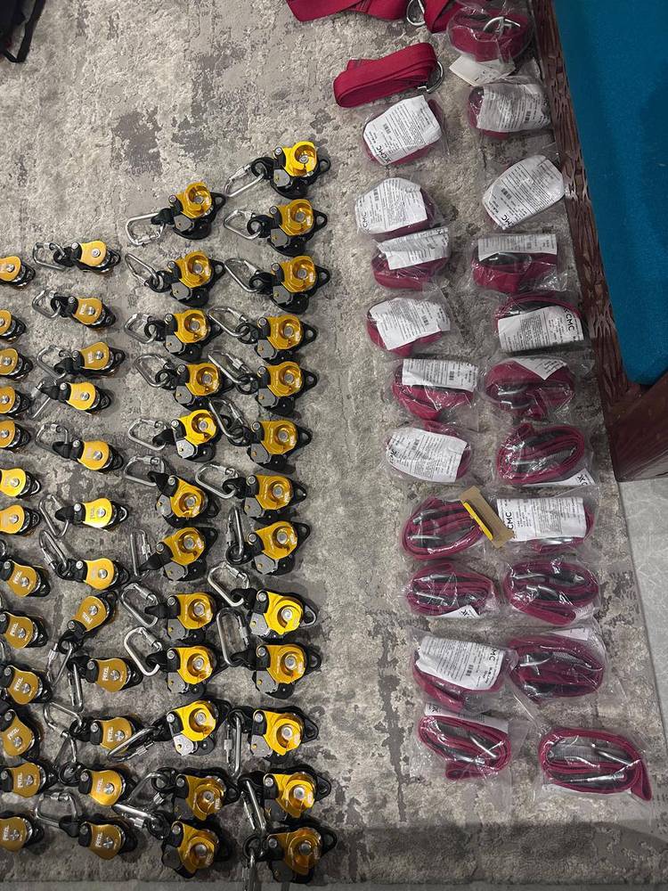 Rows of Petzl pulleys and rope grabs beside packaged CMC slings in stock